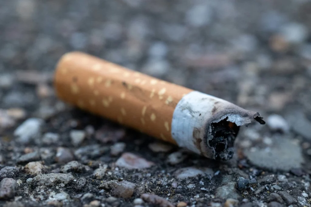 A broken cigarette on a plain background, representing giving up smoking